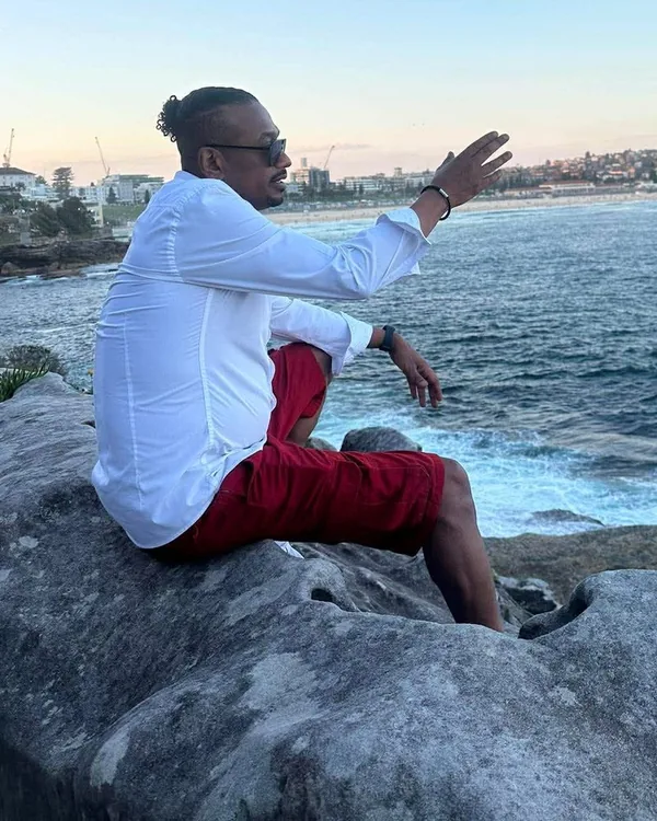 Khalid Mohamed sitting on a rock above the ocean